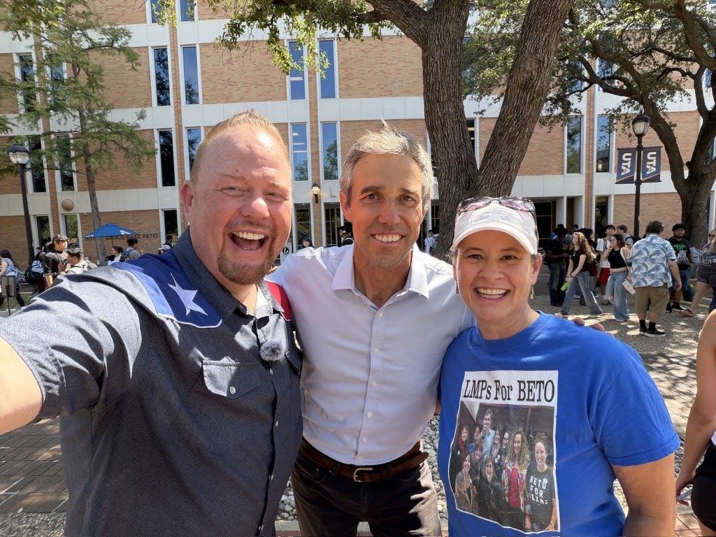 Danny Minton, Beto O'Rourke and a supporter in a Beto T-shirt smiling for a selfie outdoors on the UT Arlington campus